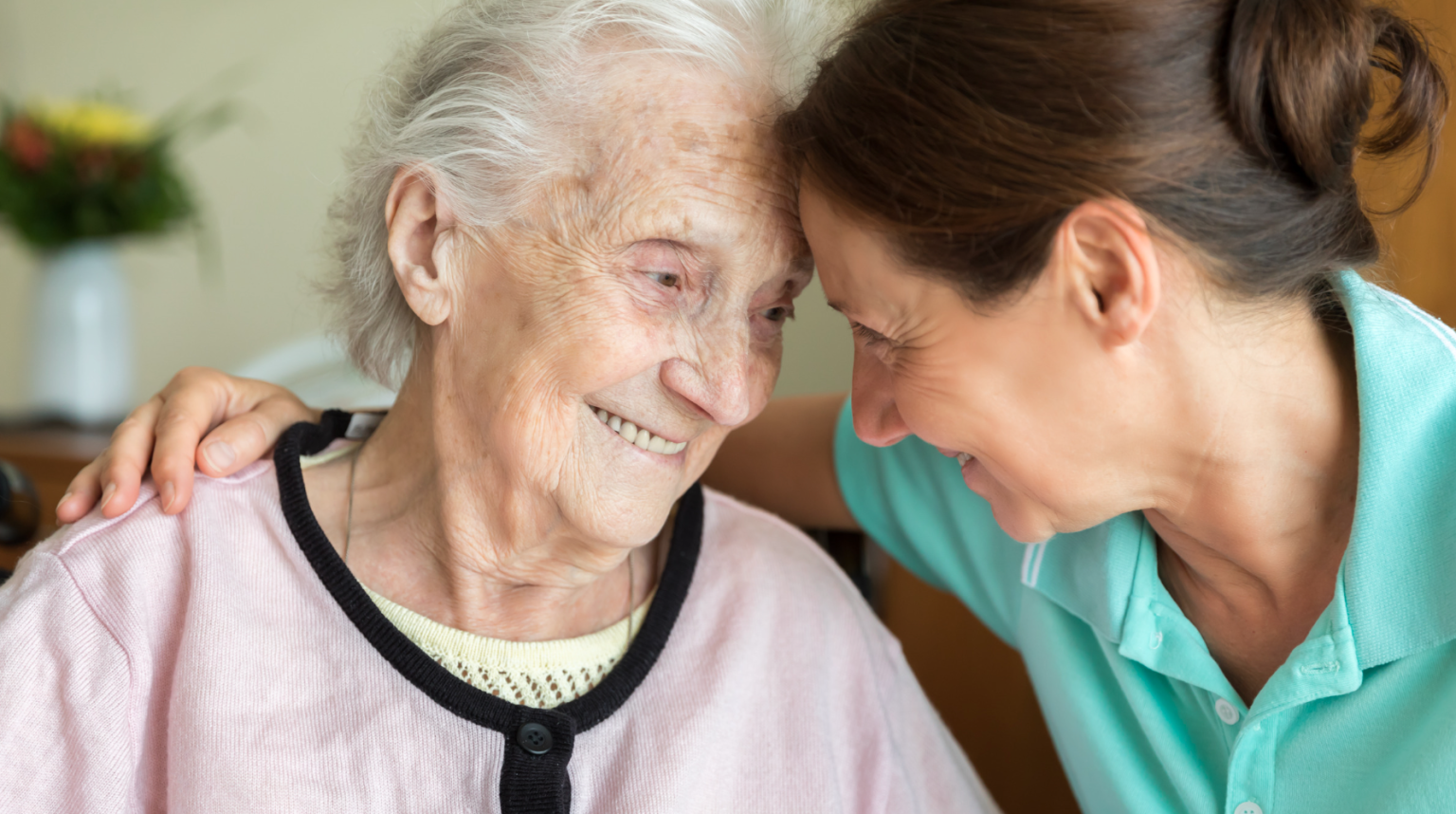 A woman comforting an elderly woman with Alzheimer’s Disease