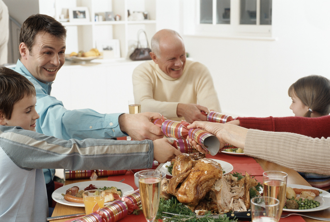 Family Pulling Party Favors During Christmas Dinner