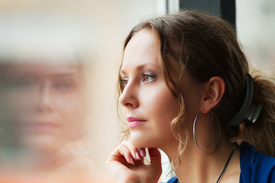 woman looking through the window pane