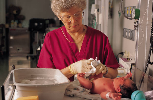 nurse bathing a newborn