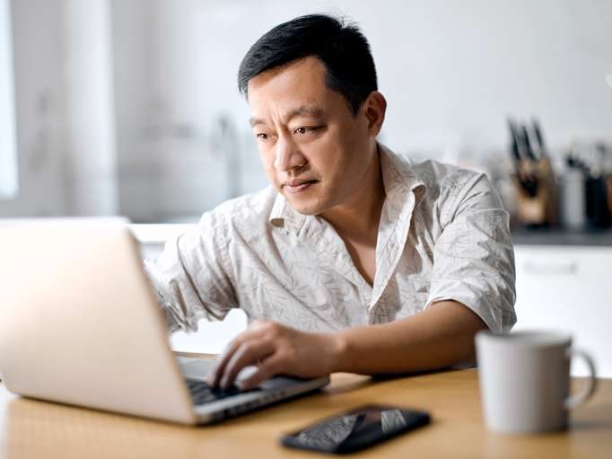 Middle-aged man working on his digital estate while sitting at table