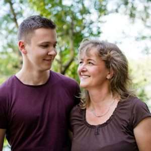 Happy mother and son outdoors. Nature background.