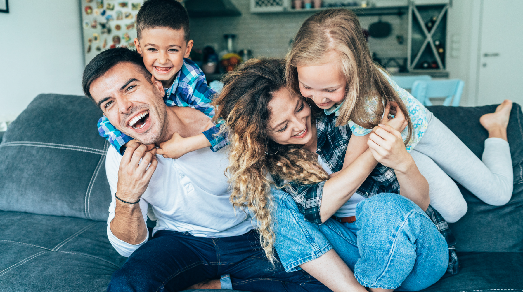 Trusts concept: Young family playing on couch at home.