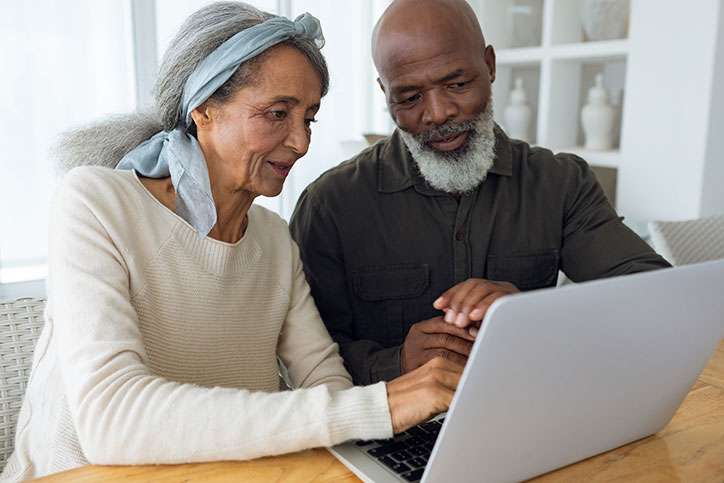 Couple looking over the medicaid look-back period on their laptop