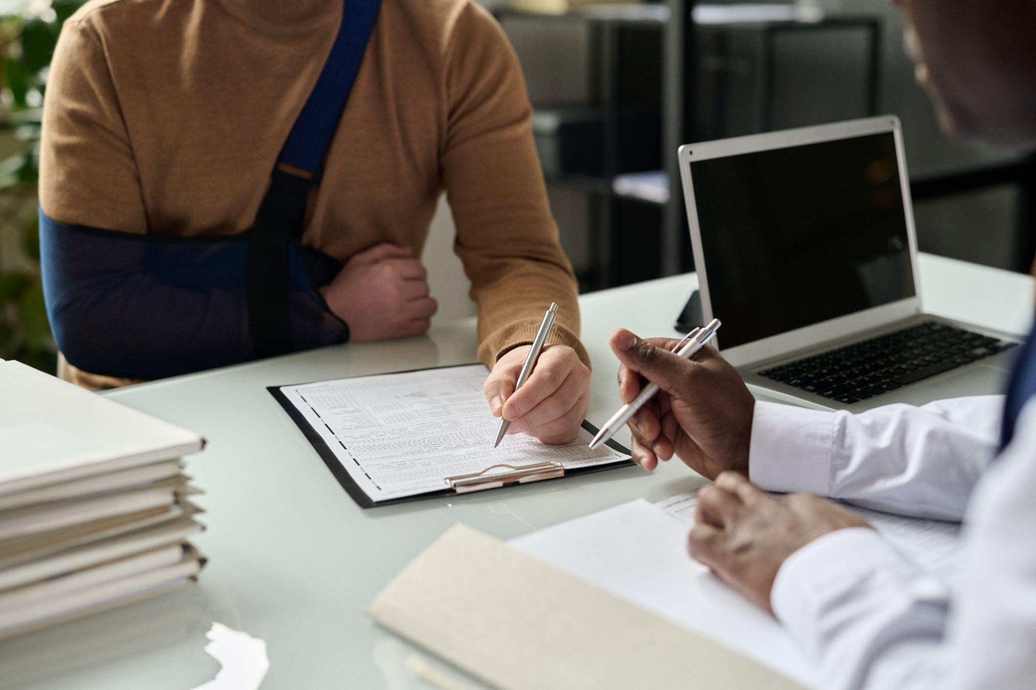 Couple reviewing advance directives with attorney, signing with witnesses present